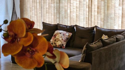 a living room with a brown couch with orange flowers at Iguazu Hojas Verdes in Puerto Iguazú