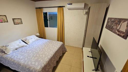 a small bedroom with a bed and a window at Iguazu Hojas Verdes in Puerto Iguazú