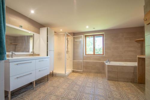 une salle de bain avec un lavabo, une baignoire et une douche dans l'établissement Gite Mondurausse - avec piscine et vue sur la vallée, à La Salvetat-Belmontet
