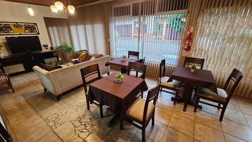 a living room with tables and chairs and a couch at Iguazu Hojas Verdes in Puerto Iguazú