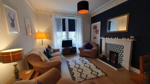 a living room with a couch and a fireplace at Beautiful Ground Floor Flat near Haymarket in Edinburgh
