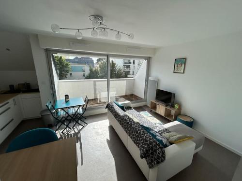 un salon avec un canapé et une grande fenêtre dans l'établissement Joli studio sur le port, à Pornic