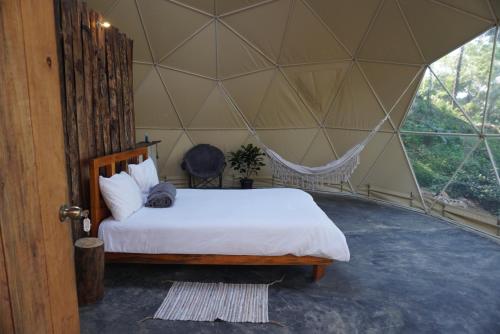 a bedroom with a bed in a tent at NOMAD Domes Sky Watching at Jarabacoa in Jarabacoa