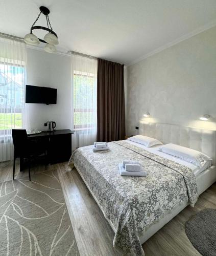 a bedroom with a bed and a desk and a computer at Villa Alessia in Skhidnitsa