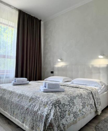 a bedroom with two beds and a large window at Villa Alessia in Skhidnitsa