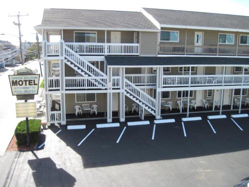 a large building with a balcony with tables and chairs at Green Dolphin in Old Orchard Beach