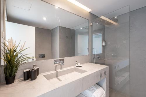 łazienka z umywalką i dużym lustrem w obiekcie Vale do Gaio Hotel w mieście Torrão