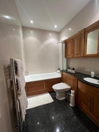 een badkamer met een bad, een toilet en een wastafel bij Victorian convent in Windsor