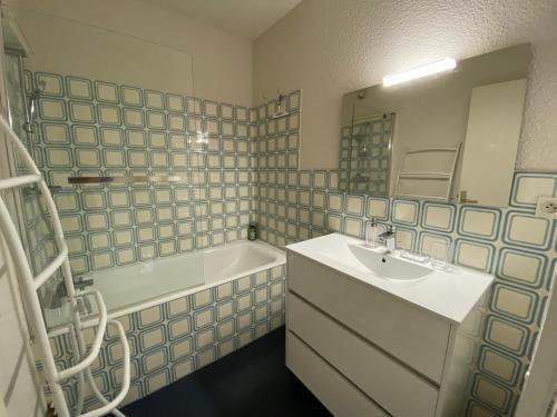 a bathroom with a sink and a tub and a mirror at C219 -2 pieces avec parking proche plage in Arcachon