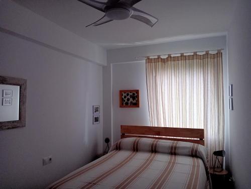 um quarto com uma cama e uma ventoinha de tecto em La Paloma em Córdoba