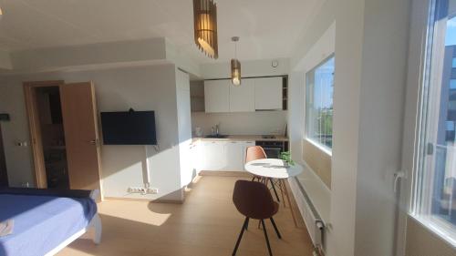 1 dormitorio con cama, mesa y cocina en Heli apartment, en Tallin
