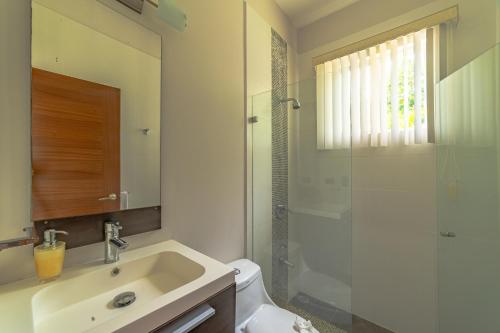 a bathroom with a toilet and a sink and a shower at Villa Jardin By Vacation Pura Vida in Esterillos