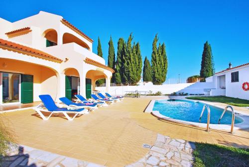 a villa with a swimming pool and lounge chairs at Villa La Romana by Algarve Vacation in Albufeira