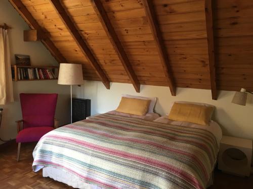 1 dormitorio con 1 cama y 1 silla roja en Bellevue en San Carlos de Bariloche