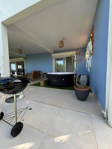 a room with a blue wall and a grill in a house at Villa Noo La in Le Robert