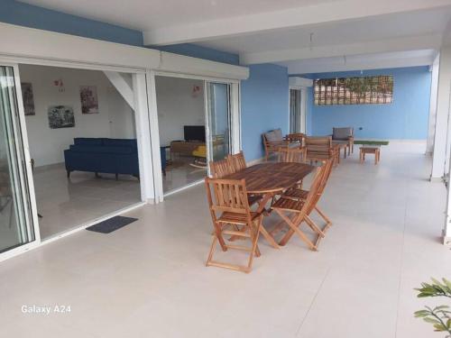 a living room with a wooden table and chairs at Villa Noo La in Le Robert
