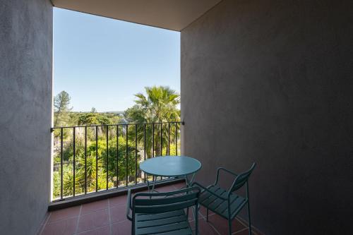 a balcony with a table and chairs and a window at Vale do Gaio Hotel in Torrão