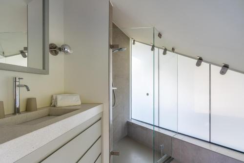 a bathroom with a glass shower and a sink at Duynzoom 5 in De Koog