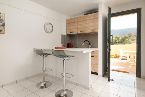a kitchen with a counter and stools in a room at Blue Horizon Apartments in Stalida