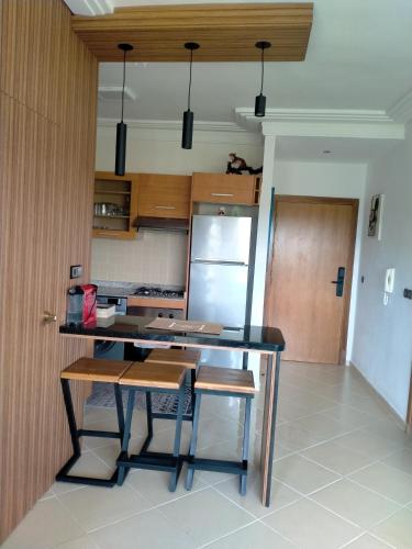 a kitchen with a table and a refrigerator at assilah marina golf assilah in Asilah