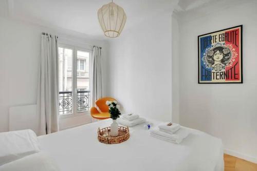 une chambre blanche avec un lit blanc et une chaise orange dans l'établissement Le petit palais de L'Élysée, à Paris