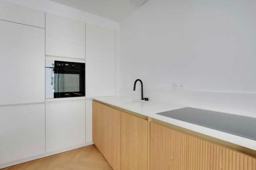 une cuisine avec un évier et un micro-ondes dans l'établissement Le petit palais de L'Élysée, à Paris