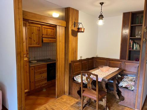 eine Küche mit einem Tisch und eine Küche mit einer Theke in der Unterkunft Menz campiglio in Madonna di Campiglio