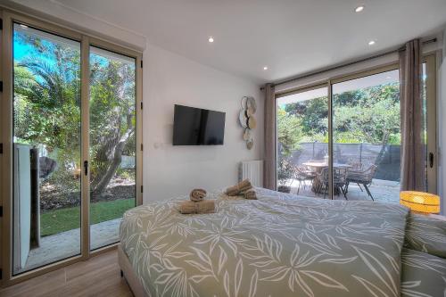 een slaapkamer met een bed en een glazen schuifdeur bij Le Greg - Terrasse - Parking - VCA in Cannes