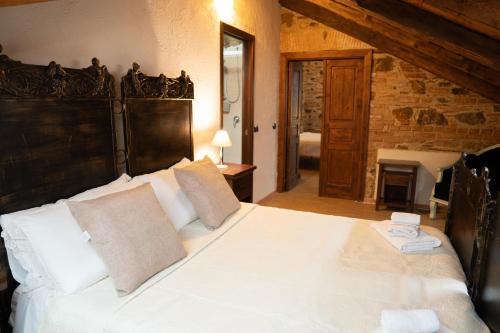a bedroom with a large white bed and a fireplace at Residenza L'Antico Borgo Hotel in Filadelfia