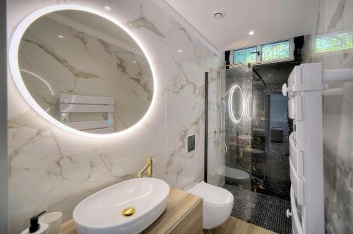 een witte badkamer met een wastafel en een spiegel bij Le Greg - Terrasse - Parking - VCA in Cannes