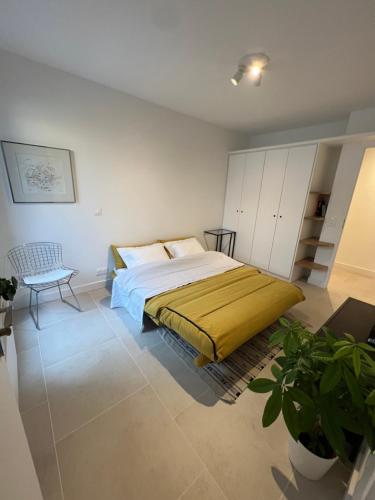 a bedroom with a bed and a chair in it at Studio indépendant avec terrasse in Villejuif