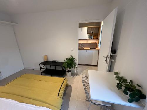 Cette chambre comprend un lit, une table et une cuisine. dans l'établissement Studio indépendant avec terrasse, à Villejuif