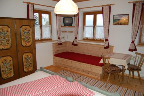 a bedroom with a bed and a table and a tv at Großberghof in Taxenbach