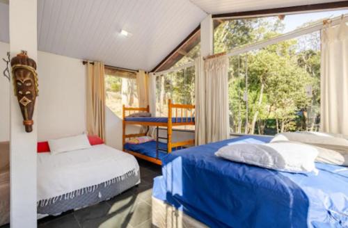 a bedroom with two beds and a window at Chácara Paraíso Mairiporã in Mairiporã