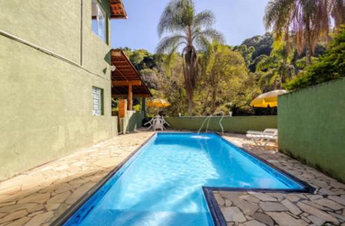 邁里波朗的住宿－Chácara Paraíso，一座大型蓝色游泳池,位于房子旁边