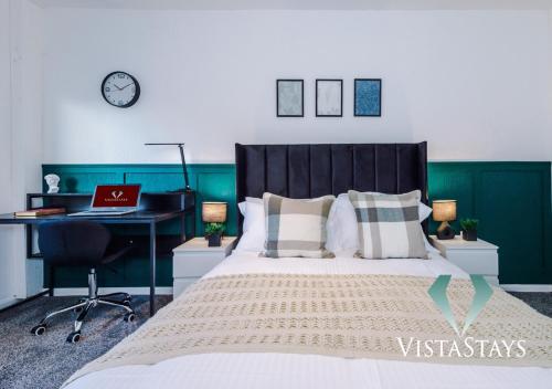 Schlafzimmer mit einem Bett und einem Schreibtisch mit einem Laptop in der Unterkunft NEW Modern 4 Bed Property with Pool Table in Manchester by Vista Stays in Manchester