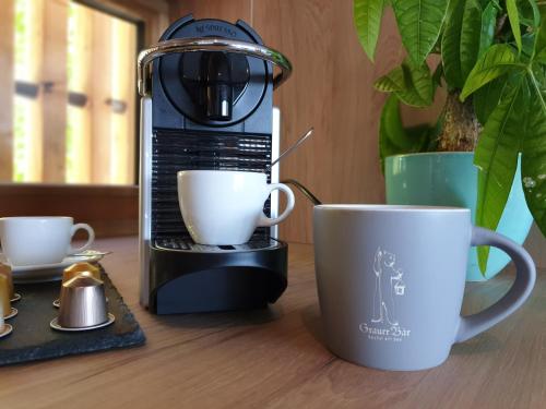 a coffee maker and two coffee cups on a table at Seehaus am Kochelsee in Kochel