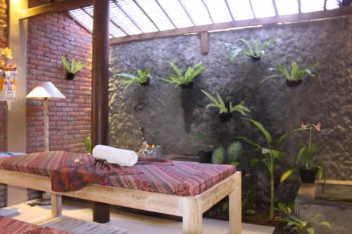 a room with a bench with potted plants on the wall at Umaya Ubud Villa in Ubud
