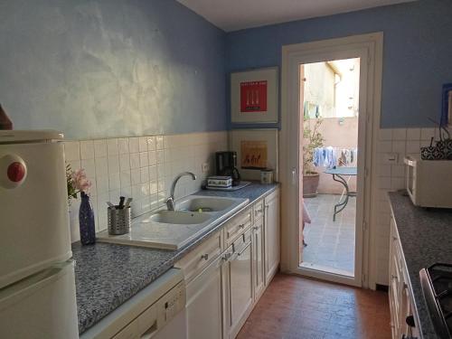 une cuisine avec un évier et un réfrigérateur dans l'établissement La Treille, à Montagnac