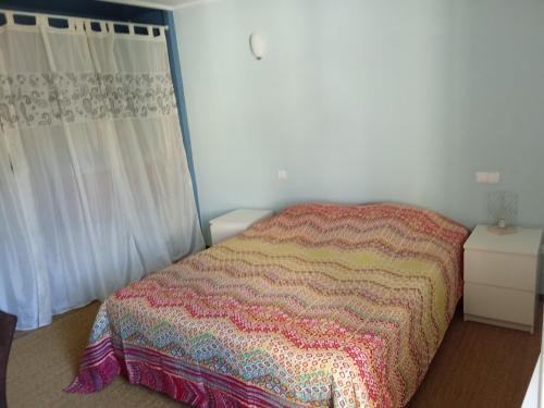 - une chambre avec un lit et une couverture colorée dans l'établissement La Treille, à Montagnac