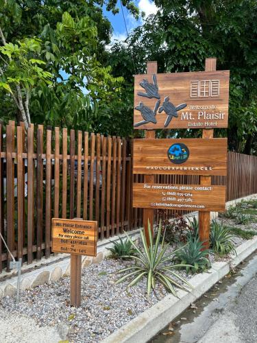 a wooden sign in front of a fence at Mt. Plaisir Estate Hotel in Grande Riviere