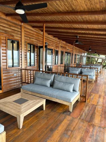 a living room with couches and tables and windows at Mt. Plaisir Estate Hotel in Grande Riviere