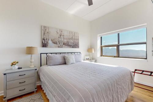 a white bedroom with a bed and a window at Citadel 3728 in Sugar Mountain