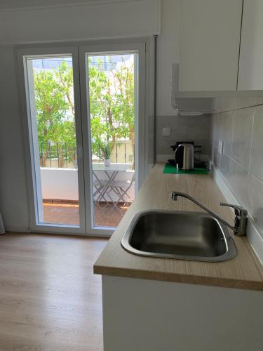 a kitchen with a sink and a view of a patio at Ciao Tavira in Tavira