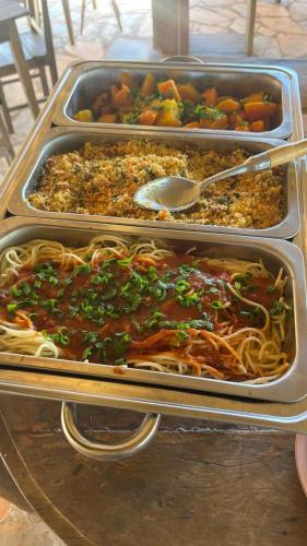 two trays of food sitting on a table at Complexo Luquinha in Iacaiá