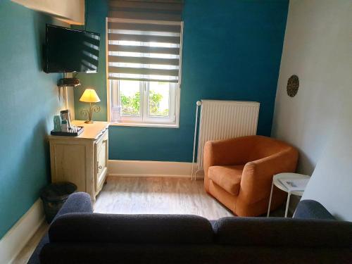 ein Wohnzimmer mit einem Sofa, einem Stuhl und einem Fenster in der Unterkunft Le Heron Pourpre B&B gastronomique in Cronat
