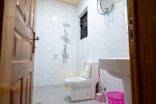 uma casa de banho branca com um WC e um lavatório em Venus VIP VILLA SUITES em Kigali