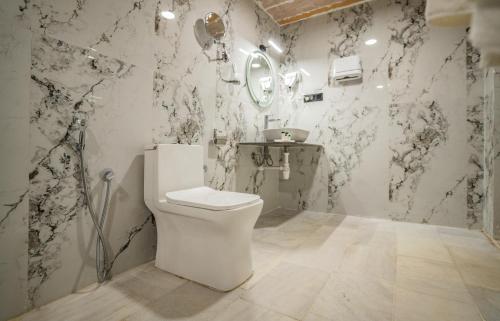 La salle de bains est pourvue de toilettes blanches et de papier peint noir et blanc. dans l'établissement Desert Heritage Luxury Camp And Resort, à Jaisalmer