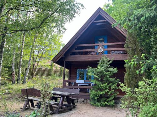 a log cabin with a picnic table and a bench at domek Pluski in Pluski