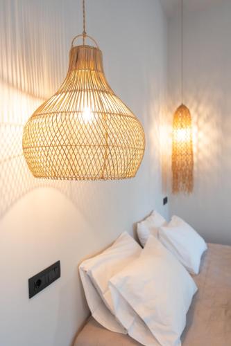 a bedroom with a bed and a hanging light at Afesou Suites in Ialyssos